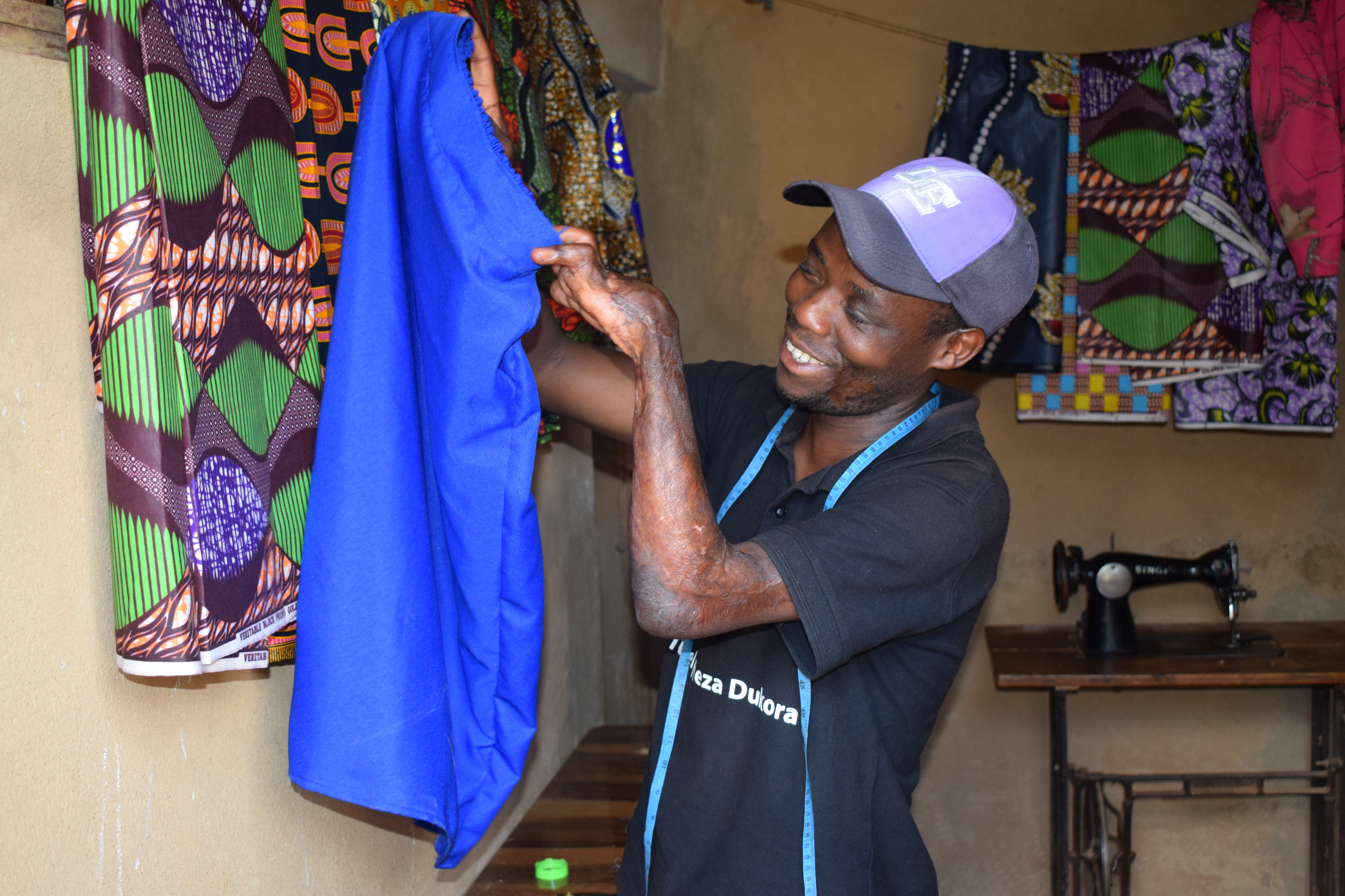 Tuyisenge showing a skirt that he just made.