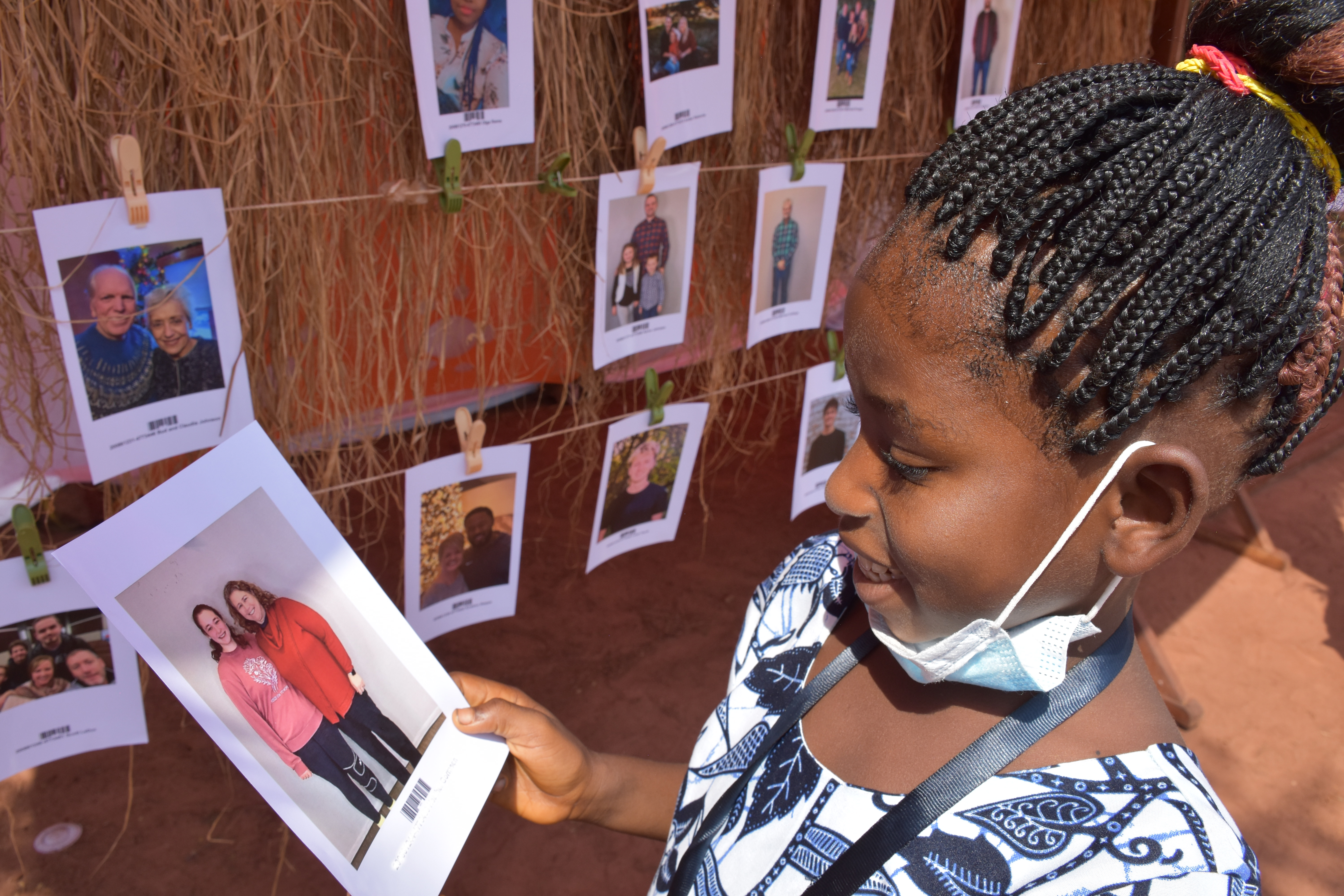 Une enfant tenant la photo de son parrain