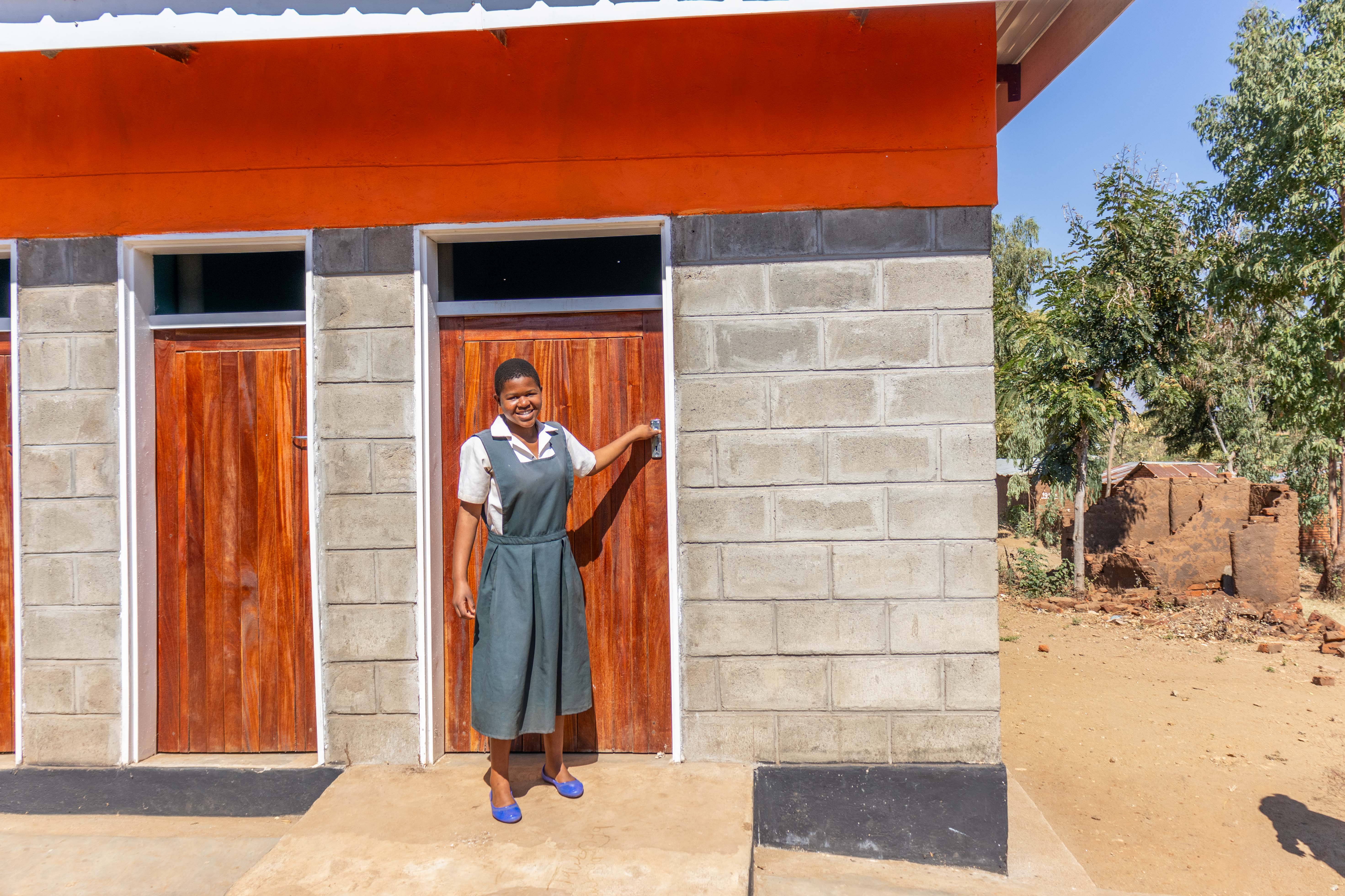 Kettie, 16, coming out of the washrooms constructed by World Vision