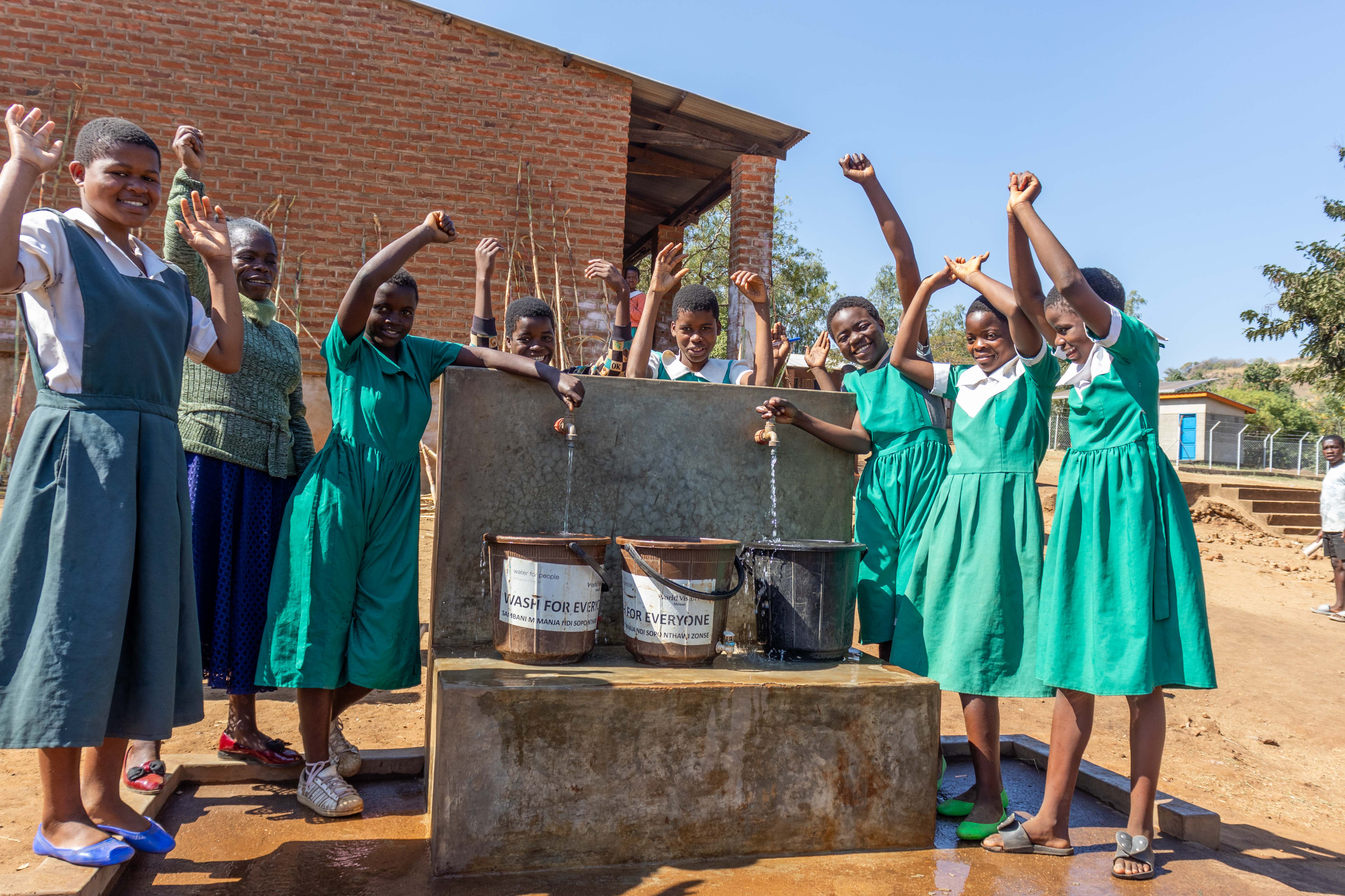 Kattie and her friends celebrating water availability at their school.