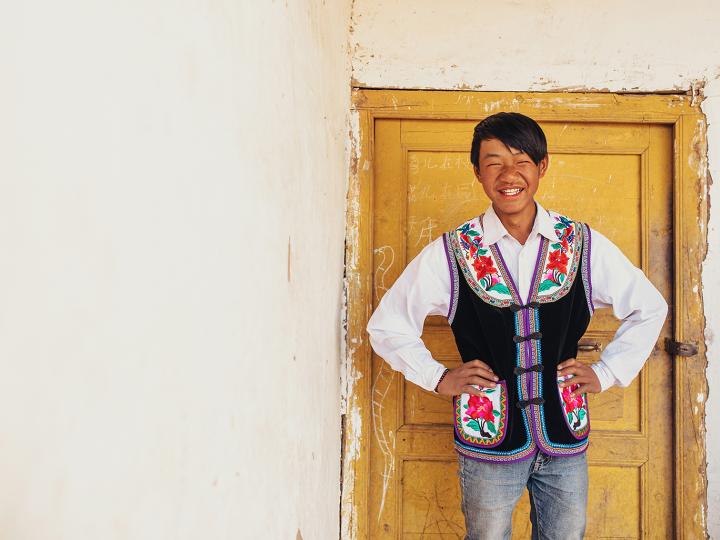 A boy stands near his home in China