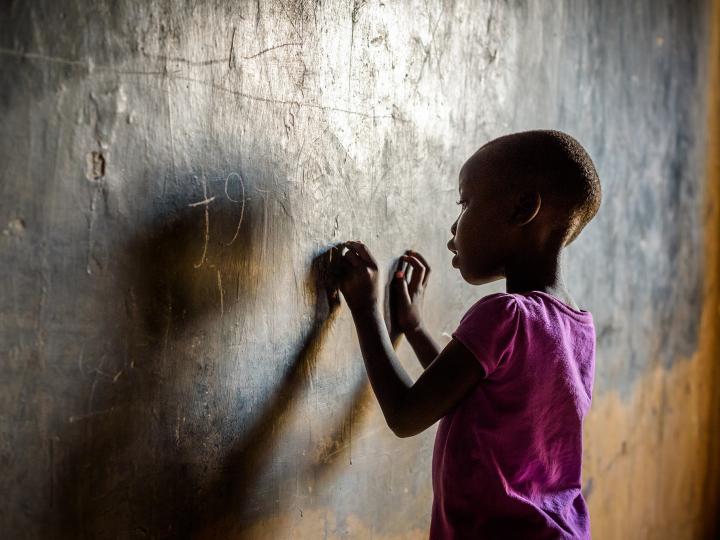 An African girl writes on a Chalkboard