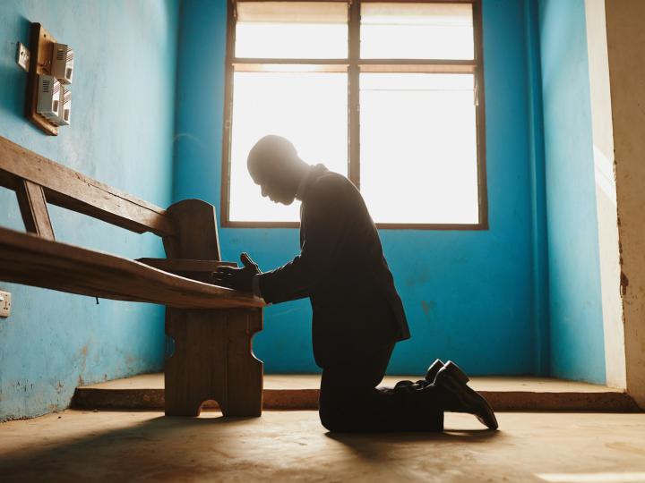 Man kneeling to pray in Ghana
