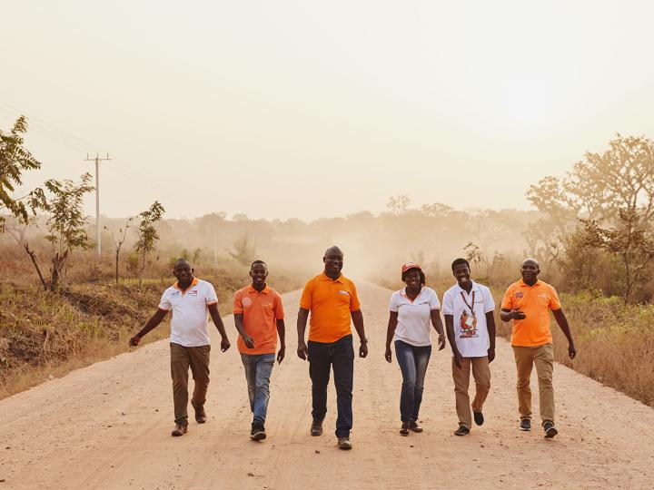 World Vision employees walk down a road in Ghana