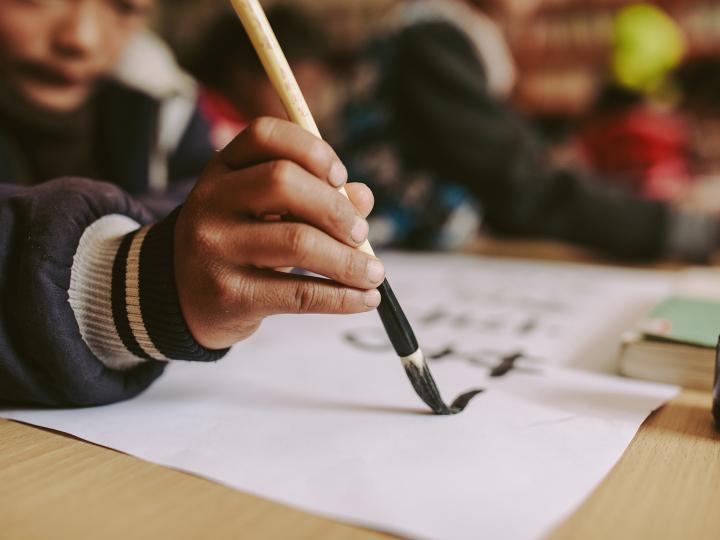 A Chinese boy writes on a paper