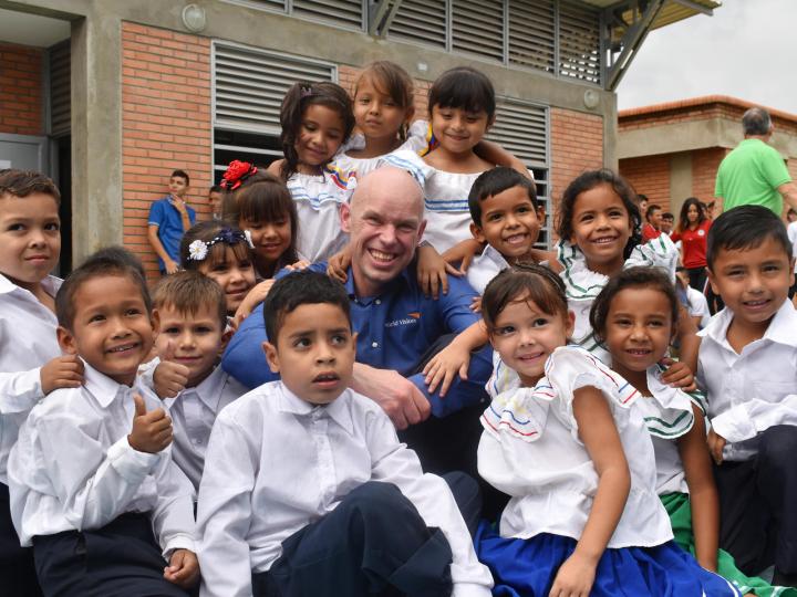 WVI President Andrew Morley sits with children in Colombia