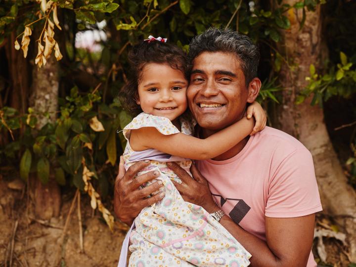 A father holds his daughter in rural Colombia