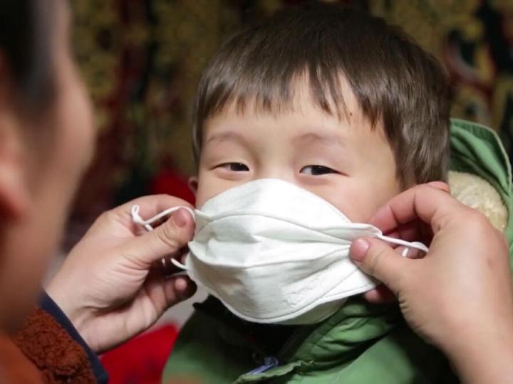 How we'll get there, mother puts mask on her child 