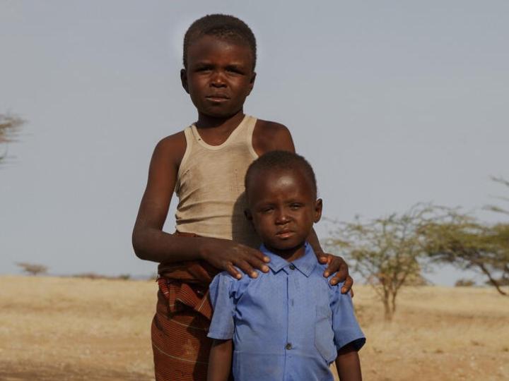 4-year-old Sunday, and his 9-year-old brother Blue, stand in the middle of an almost deserted field.