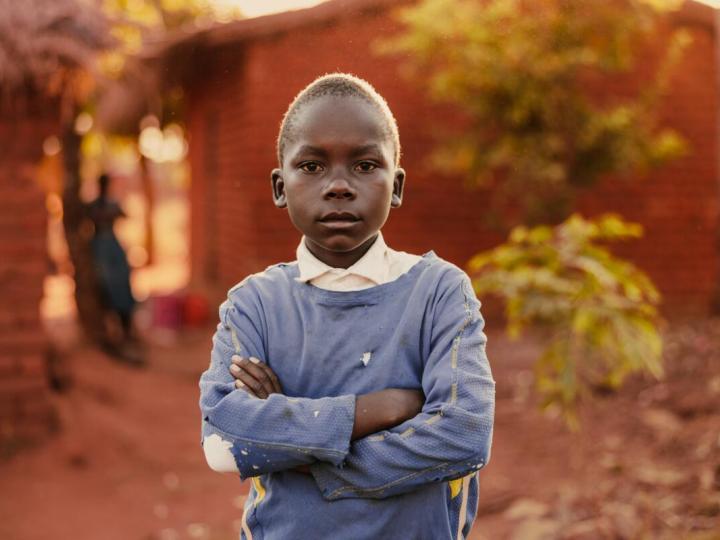 A child standing with crossed hands