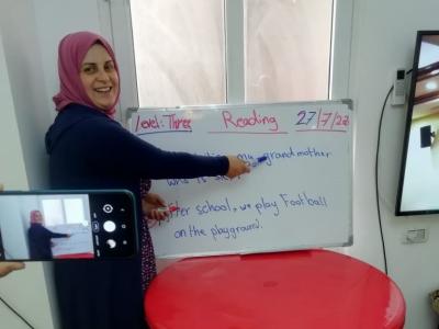 Nahed, remedial class teacher, explains a lesson on camera so as to send the video later to her students