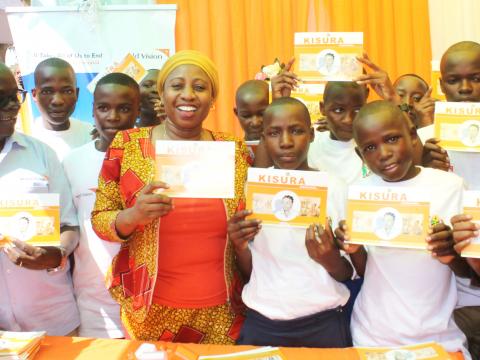 In a group photo are Hon. Ummy Mwalimu Minister for Health, Community Development, Gender, Elderly and Children (3rd left); Gilbert Kamanga; WVT National Director (1st left), other stakeholders and children from Nzega and Kagera APs.