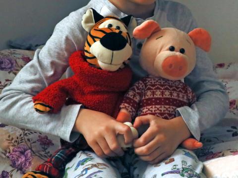 Child holding stuffed animals